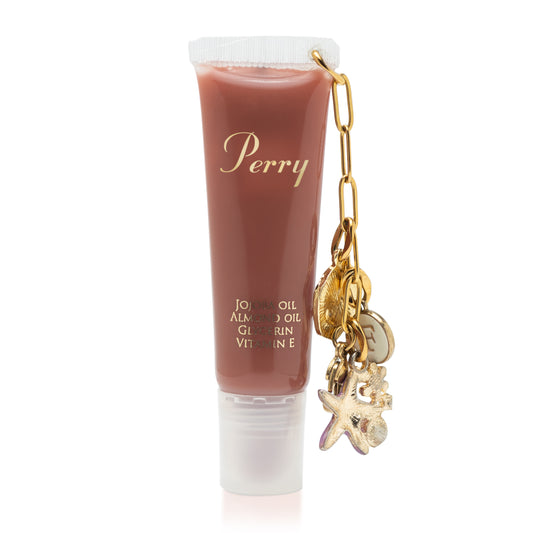 Lip balm tube with 'Perry' branding and a gold chain with charms on a white background